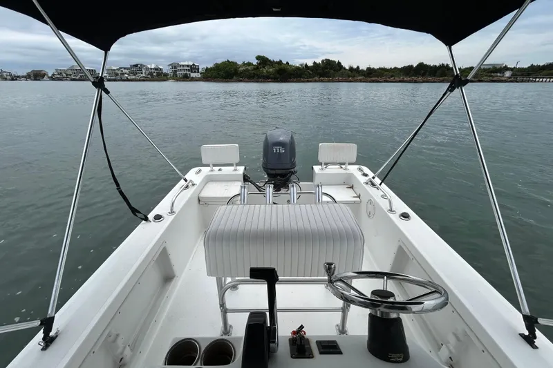 Slide: The Image of 2009 KenCraft 2060 boat interior with steering wheel and outboard motor on calm water. - 19
