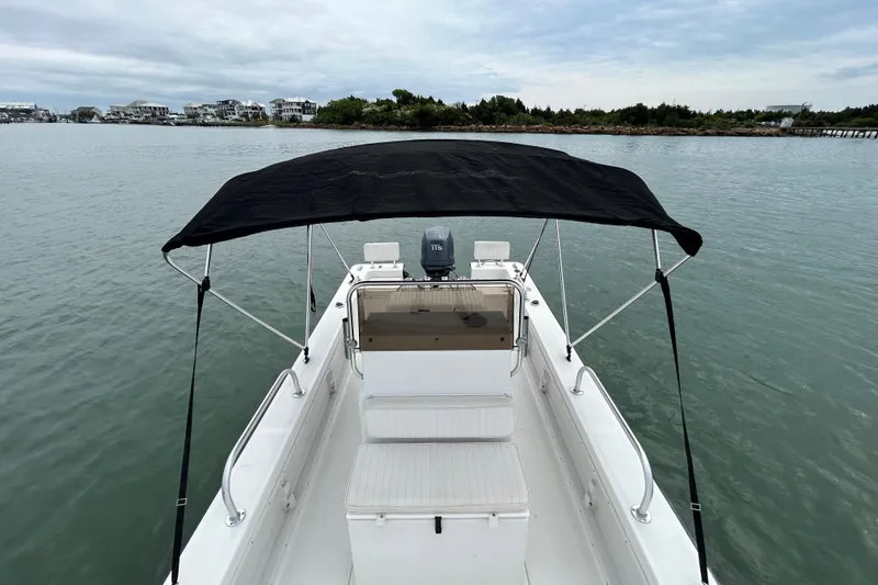 Slide: The Image of 2009 KenCraft 2060 boat with canopy on calm water, coastal background. - 30