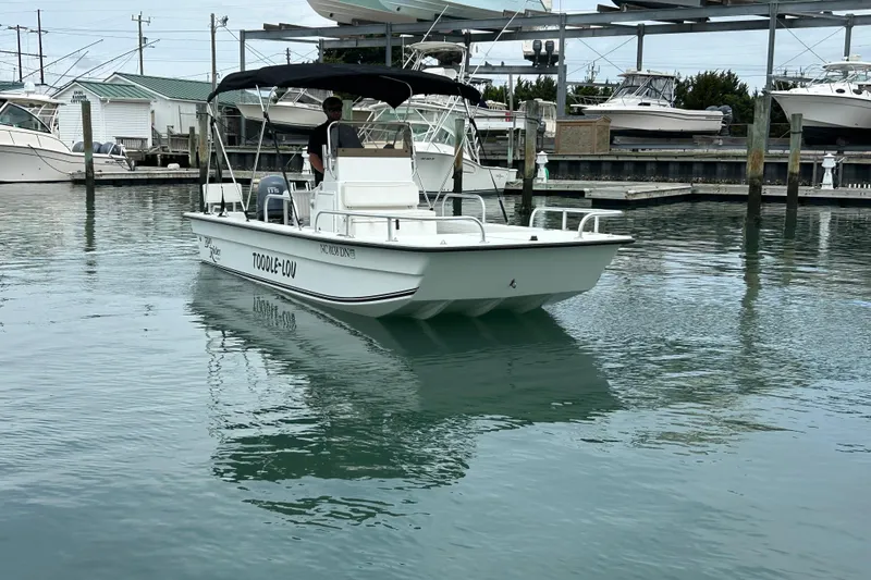 Slide: The Image of 2009 KenCraft 2060 boat docked in a marina, featuring a canopy and calm waters. - 7
