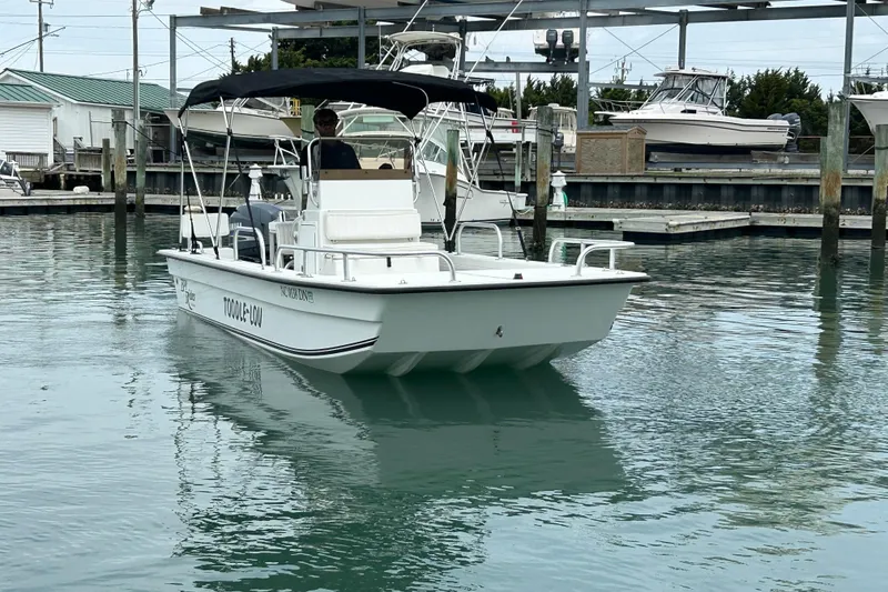 Slide: The Image of 2009 KenCraft 2060 boat docked in marina, featuring canopy and calm waters. - 8