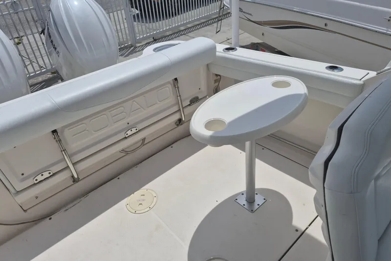 Slide: The Image of 2021 Robalo R247 Dual Console boat interior with seating and table setup. - 10