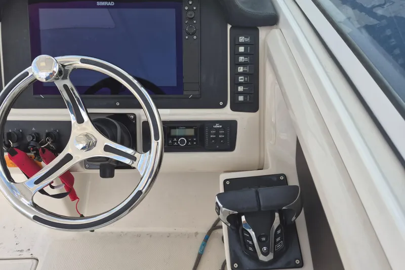 Slide: The Image of 2021 Robalo R247 Dual Console helm with steering wheel and control panel. - 14