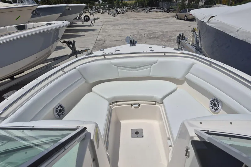 Slide: The Image of 2021 Robalo R247 Dual Console boat with spacious seating in a marina setting. - 6
