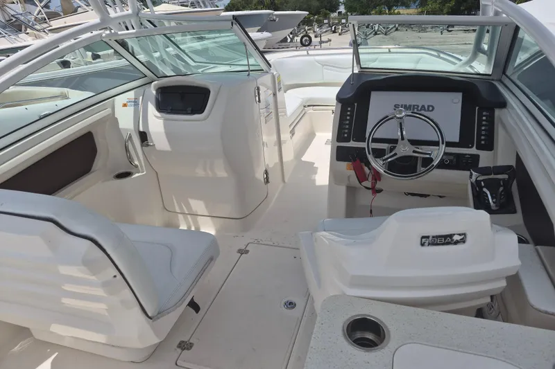 Slide: The Image of 2021 Robalo R247 Dual Console boat interior with steering wheel and seating. - 8
