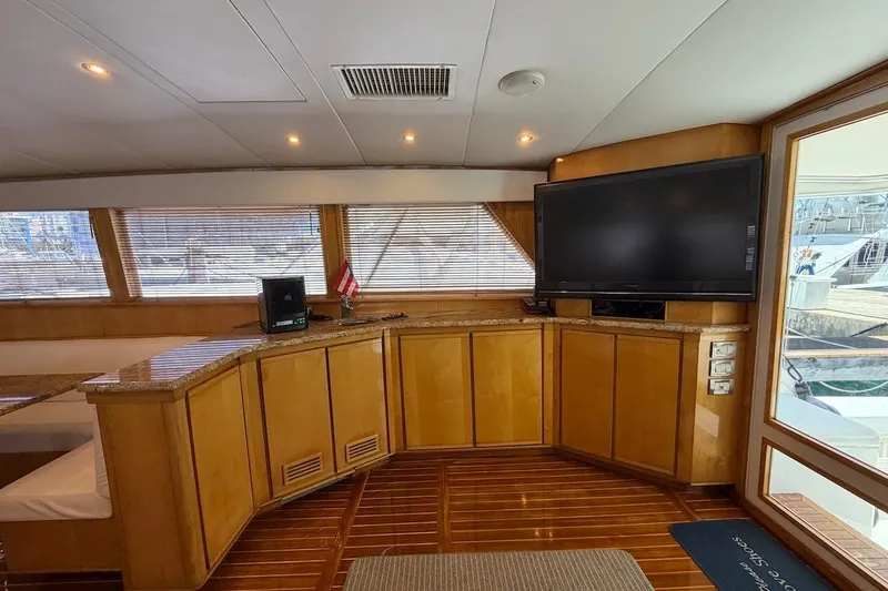 Slide: The Image of Interior of 1995 Bertram 60 Convertible yacht with wood paneling and large TV. - 19