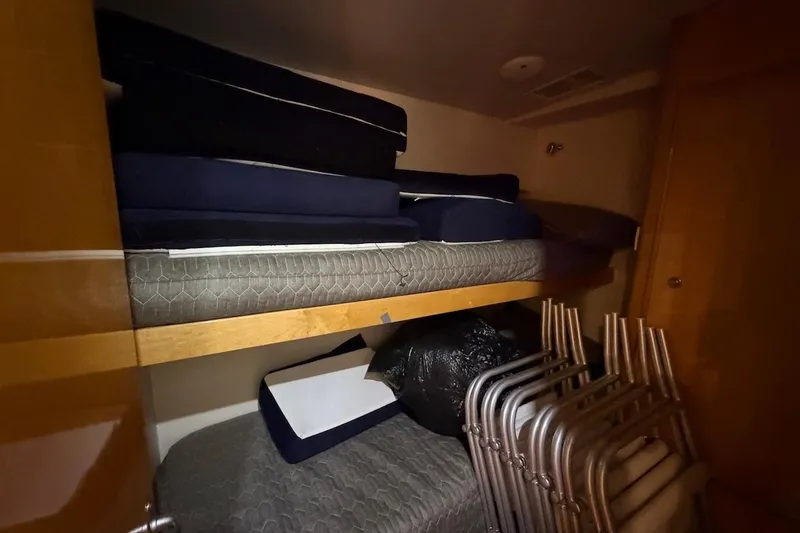 Slide: The Image of Storage area in a 1995 Bertram 60 Convertible yacht with mattresses and folded chairs. - 26