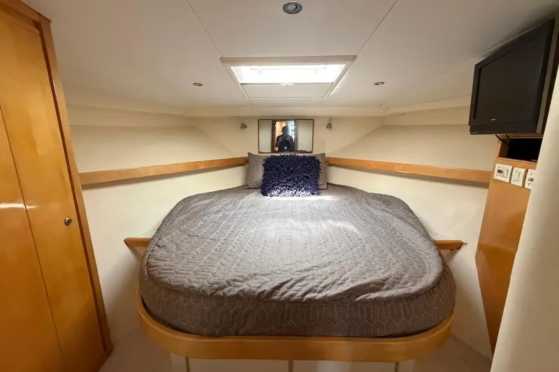 Slide: The Image of Cozy bedroom in 1995 Bertram 60 Convertible yacht with plush bedding and TV. - 33