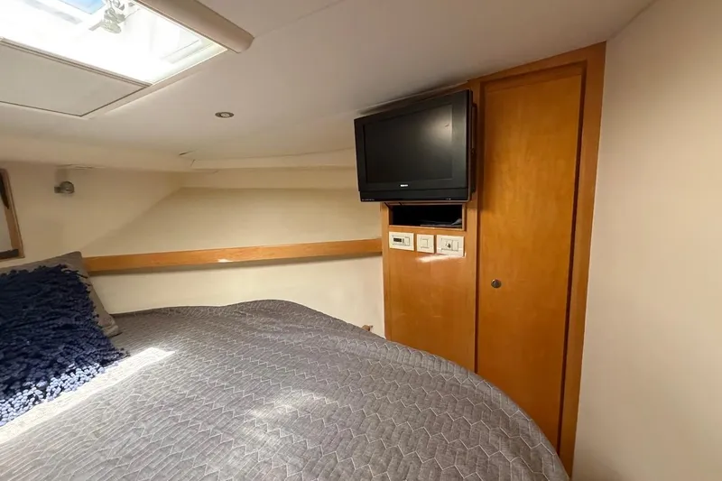 Slide: The Image of Cozy bedroom in 1995 Bertram 60 Convertible yacht with TV and skylight. - 34