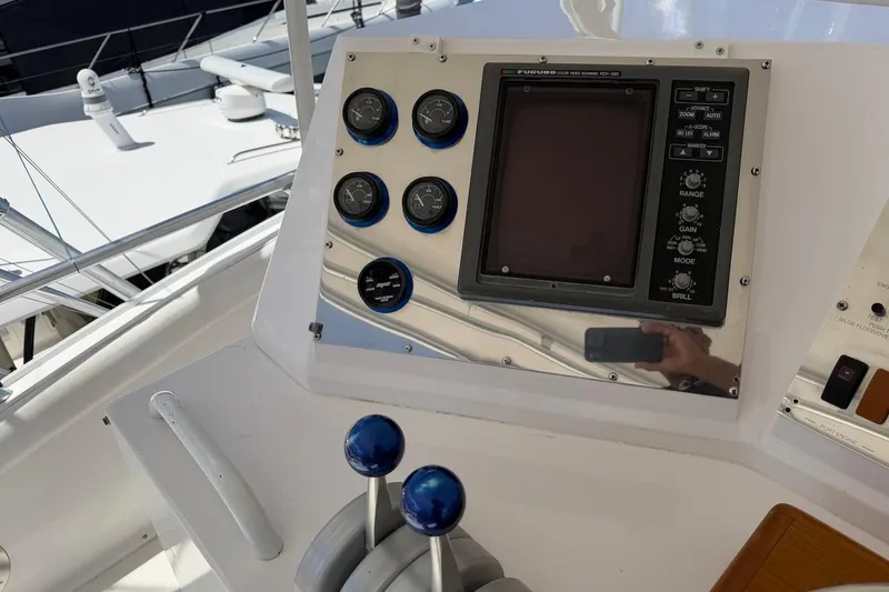 Slide: The Image of Control panel of a 1995 Bertram 60 Convertible yacht with gauges and navigation screen. - 38