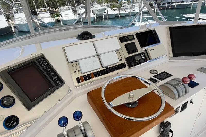 Slide: The Image of Control panel of a 1995 Bertram 60 Convertible yacht with steering wheel and navigation equipment. - 40