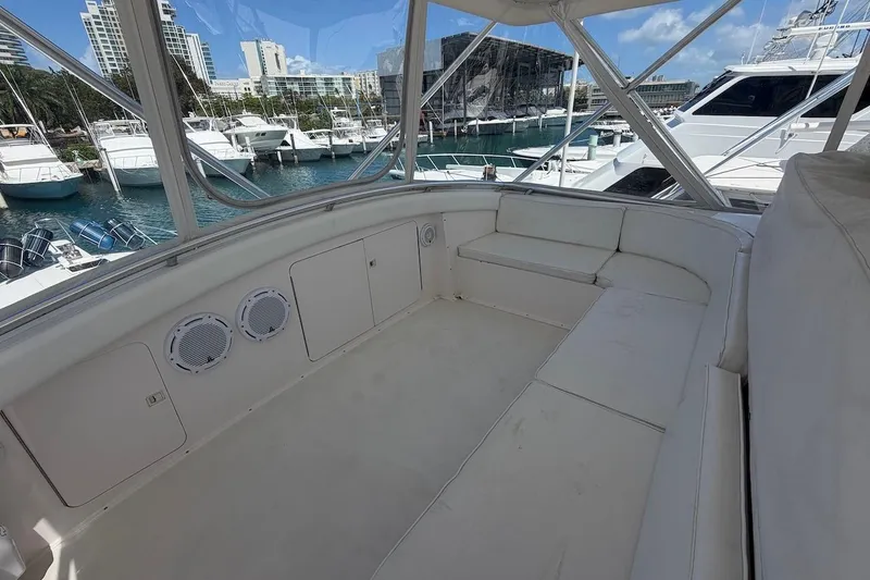 Slide: The Image of Spacious seating area on a 1995 Bertram 60 Convertible yacht, docked at a marina. - 41