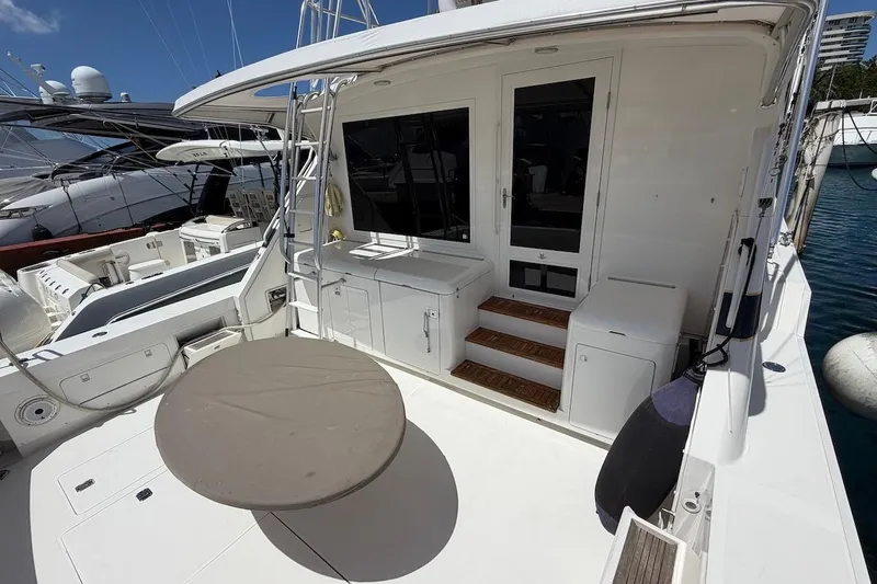 Slide: The Image of 1995 Bertram 60 Convertible yacht deck with seating and storage, docked at marina. - 42