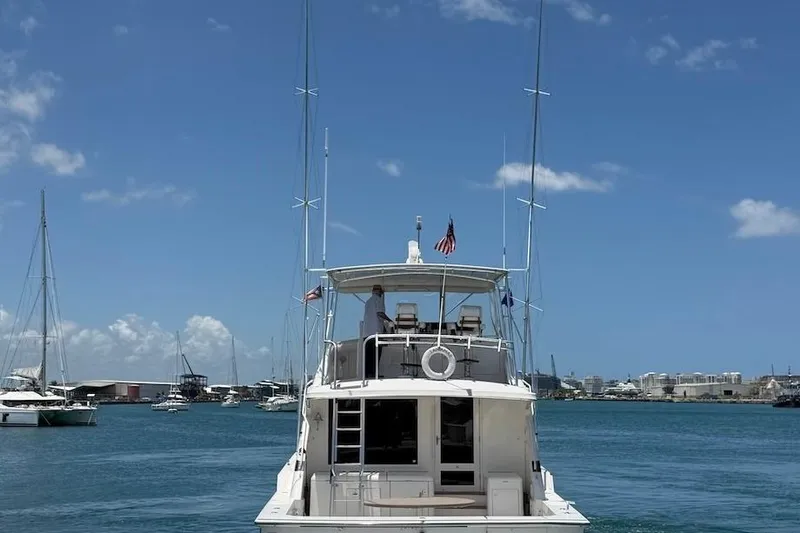 Slide: The Image of 1995 Bertram 60 Convertible yacht on calm waters under a clear blue sky. - 5