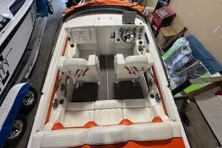 Slide: The Image of 2021 Velocity 290 Sport Cruiser interior with white and orange seating, dual helm seats. - 12