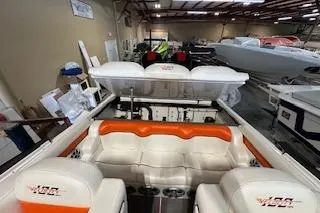 Slide: The Image of 2021 Velocity 290 Sport Cruiser interior with orange and white seating in a showroom. - 13