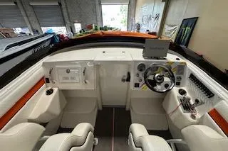 Slide: The Image of 2021 Velocity 290 Sport Cruiser cockpit with modern controls and seating in a showroom. - 14
