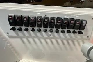 Slide: The Image of Dashboard switches on a 2021 Velocity 290 Sport Cruiser boat. - 18