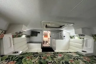 Slide: The Image of 2021 Velocity 290 Sport Cruiser cabin with floral bedding and white seating. - 25