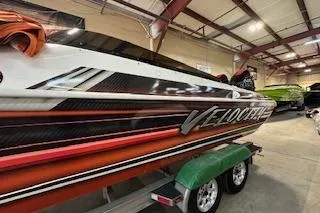 Slide: The Image of 2021 Velocity 290 Sport Cruiser boat in a showroom, showcasing sleek design and vibrant colors. - 7