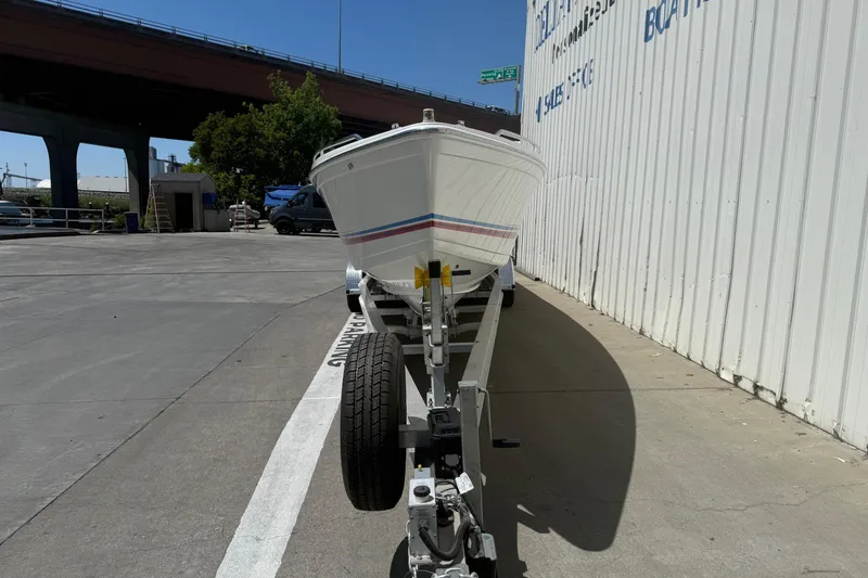 Slide: The Image of 2001 Formula 353 FASTech boat on trailer, parked beside a building under a bridge. - 2