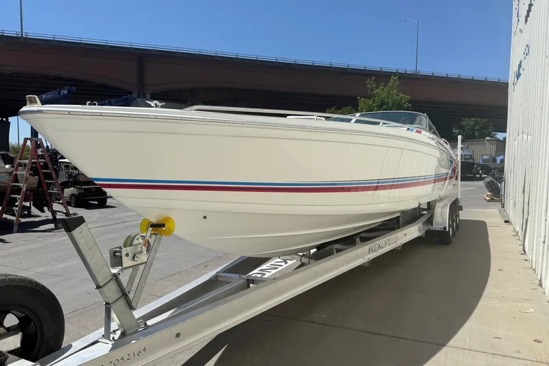 Slide: The Image of 2001 Formula 353 FASTech boat on trailer, parked outdoors under a bridge. - 3