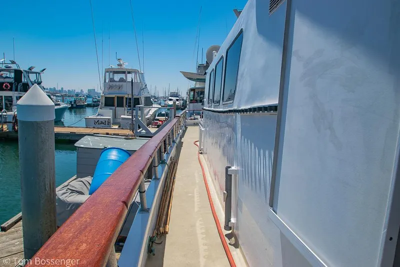 Slide: The Image of 1975 Blanchard Passenger Sportfisher docked at marina, clear blue sky, side view. - 11