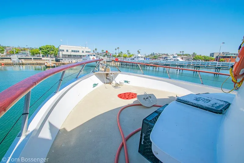 Slide: The Image of 1975 Blanchard Passenger Sportfisher boat deck with marina view, clear blue sky, and waterfront buildings. - 17