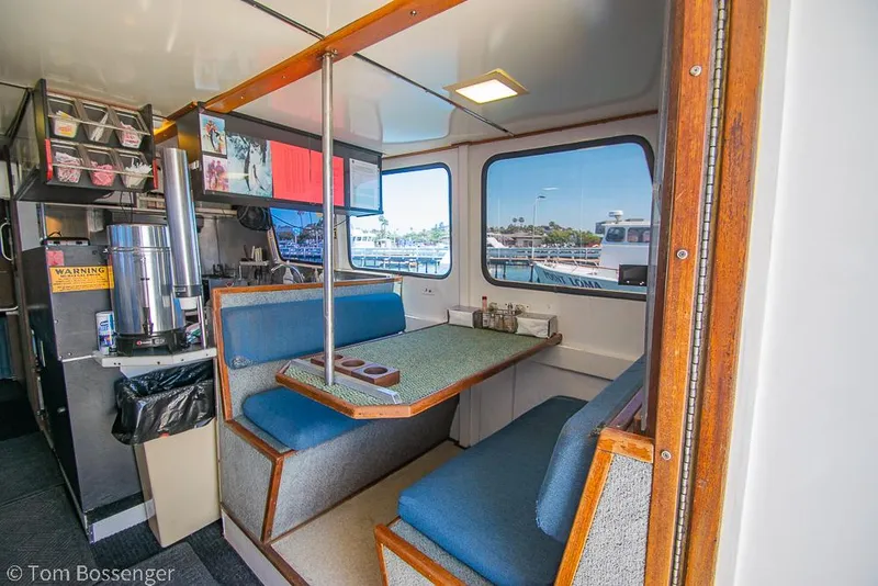 Slide: The Image of Interior of 1975 Blanchard Passenger Sportfisher with blue seating and dining area. - 46