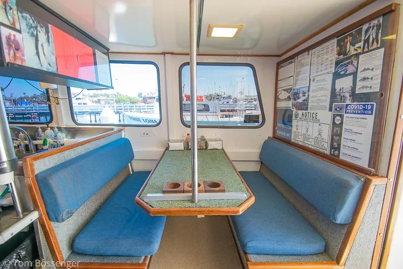 Slide: The Image of Interior of a 1975 Blanchard Passenger Sportfisher with blue seating and informational posters. - 49