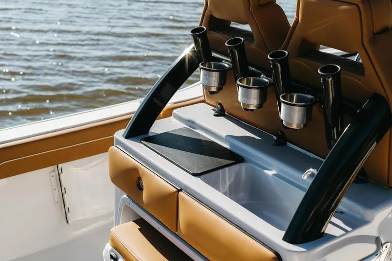 Slide: The Image of 2026 Key West 239 FSR boat interior with rod holders and seating, overlooking water. - 23