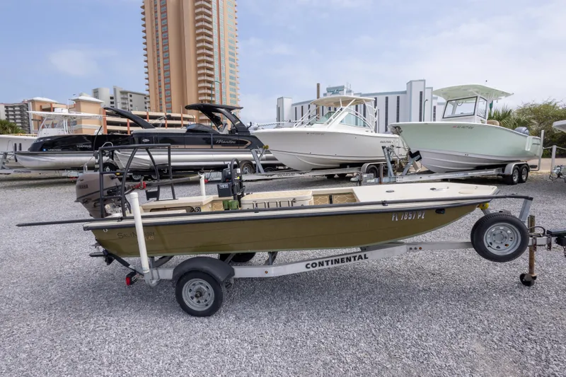 Slide: The Image of A 2016 Salt Marsh 1444 boat on a trailer, surrounded by other boats in a marina. - 8