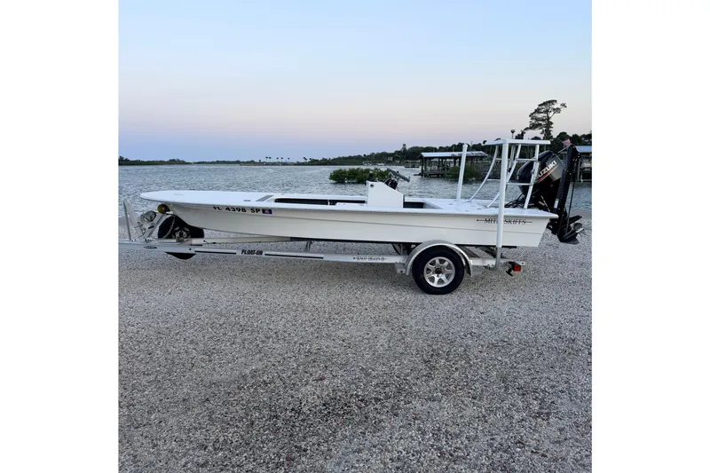 The Image of 2019 Mitzi Skiffs 17 boat on trailer by waterfront, evening sky. - 1