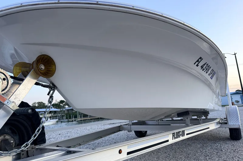 Slide: The Image of 2019 Mitzi Skiffs 17 boat on trailer, side view with registration number visible. - 10