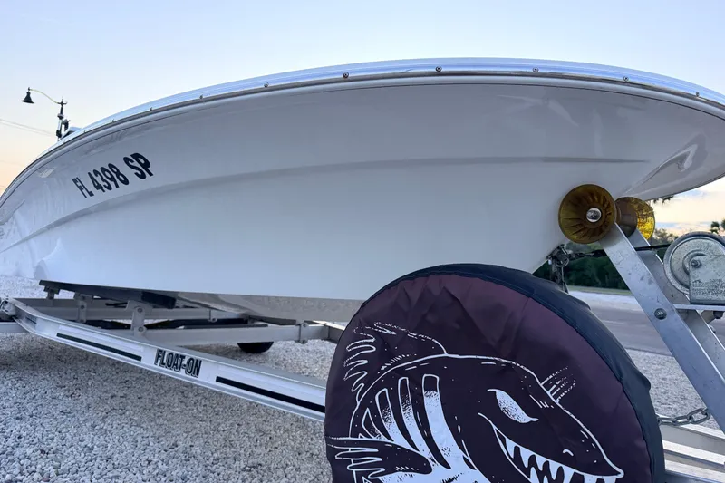 Slide: The Image of 2019 Mitzi Skiffs 17 boat on trailer, featuring a sleek white hull design. - 13