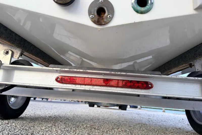 Slide: The Image of Trailer view of a 2019 Mitzi Skiffs 17 boat, highlighting the underside and rear light. - 21