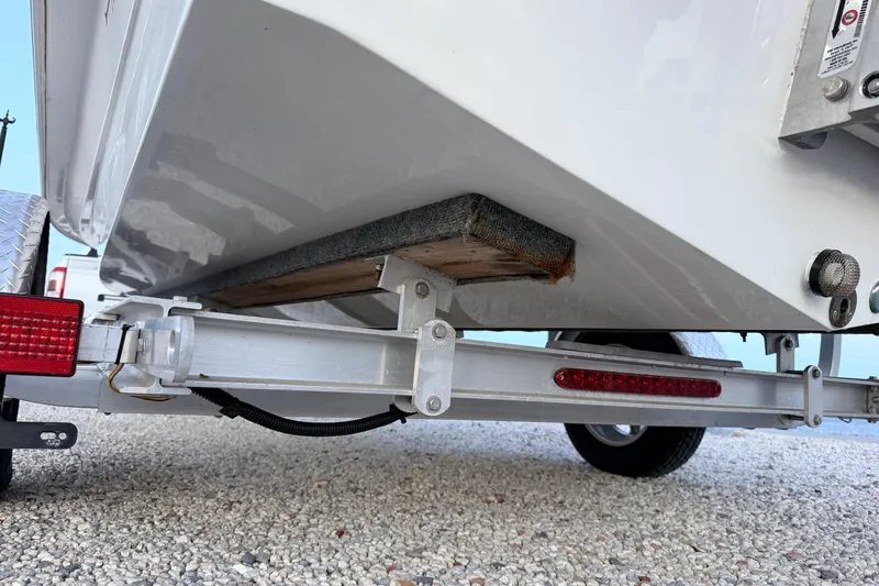 Slide: The Image of Trailer under a 2019 Mitzi Skiffs 17 boat, showing support and lighting details. - 24