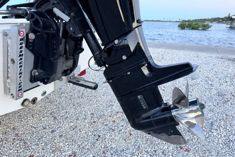 Slide: The Image of Outboard motor of a 2019 Mitzi Skiffs 17 boat on a gravel shore. - 25