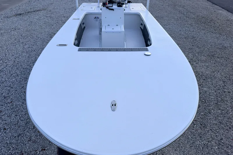 Slide: The Image of 2019 Mitzi Skiffs 17 boat on gravel, showcasing sleek design and spacious deck. - 29