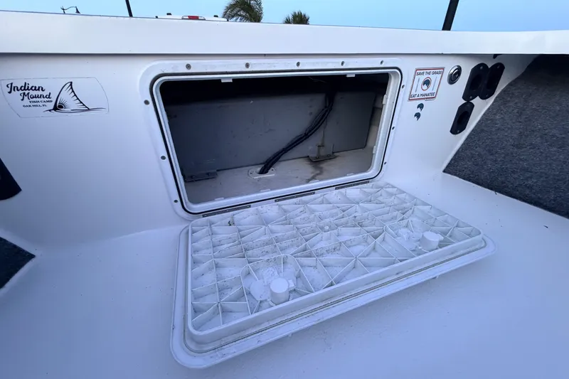 Slide: The Image of Open storage compartment on a 2019 Mitzi Skiffs 17 boat, featuring utility access. - 32
