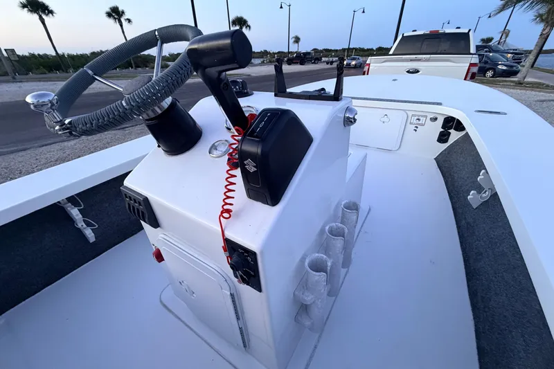 Slide: The Image of 2019 Mitzi Skiffs 17 boat console with steering wheel and controls, parked near waterfront. - 37