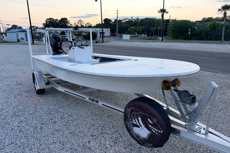 Slide: The Image of 2019 Mitzi Skiffs 17 boat on trailer, parked on gravel, with outboard motor. - 5