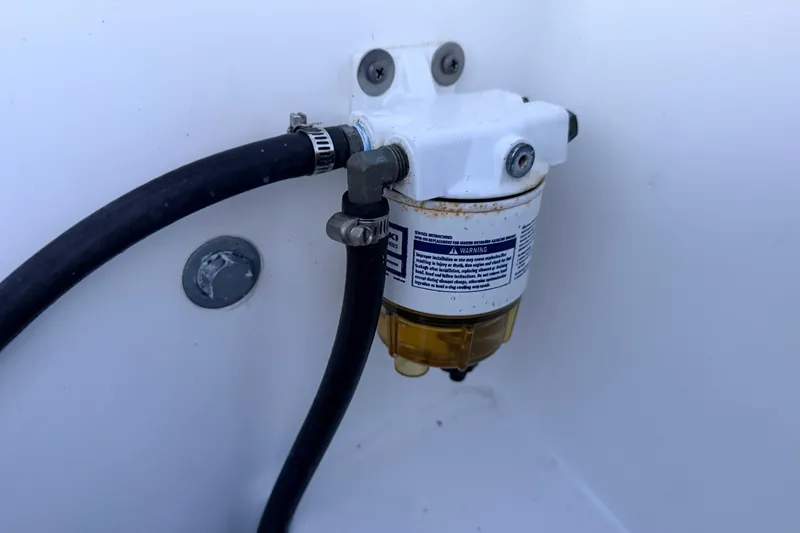 Slide: The Image of Fuel filter system in a 2019 Mitzi Skiffs 17 boat, featuring hoses and mounting hardware. - 65
