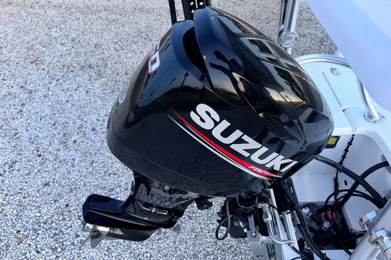 Slide: The Image of Suzuki outboard motor on 2019 Mitzi Skiffs 17 boat, parked on gravel. - 72