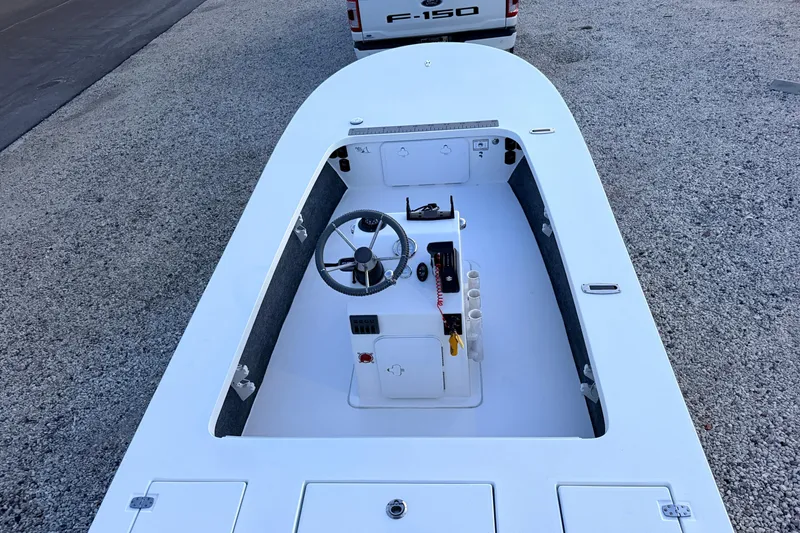Slide: The Image of 2019 Mitzi Skiffs 17 boat interior with steering console, parked on gravel. - 73