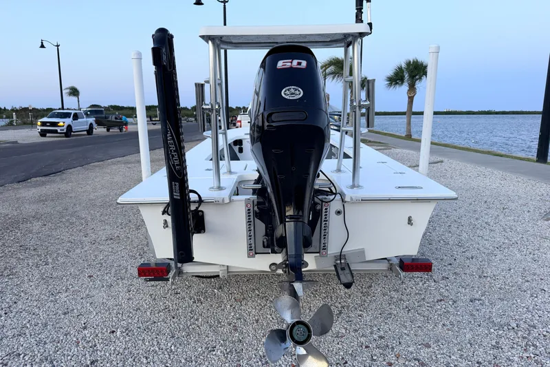 Slide: The Image of 2019 Mitzi Skiffs 17 boat with outboard motor, parked near waterfront. - 8