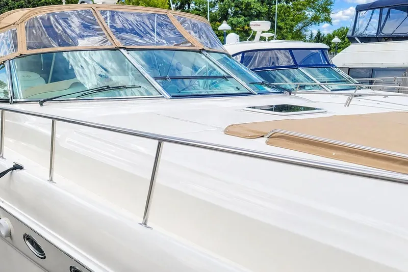 Slide: The Image of 1999 Sea Ray Sundancer 460 yacht with sleek design, docked alongside other boats. - 3