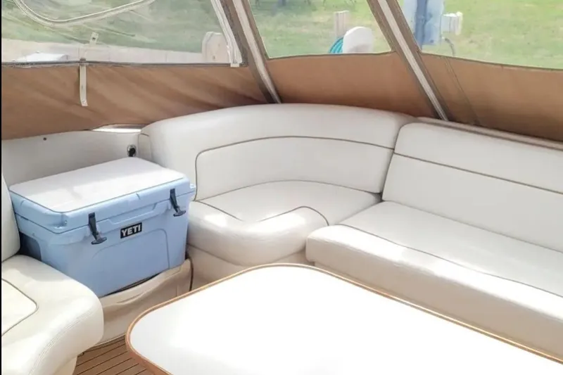 Slide: The Image of Interior of 1999 Sea Ray Sundancer 460 with white seating and a Yeti cooler. - 5