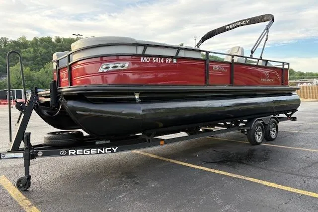 Slide: The Image of 2024 Regency 250 DL3 pontoon boat on trailer in parking lot, featuring sleek red and black design. - 10