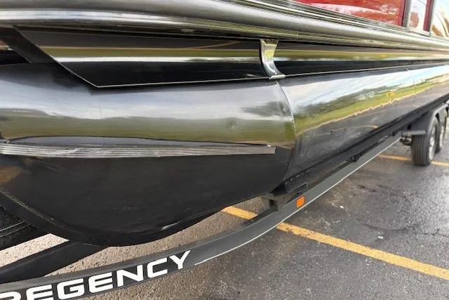 Slide: The Image of 2024 Regency 250 DL3 pontoon boat on trailer, showcasing sleek design and sturdy construction. - 13
