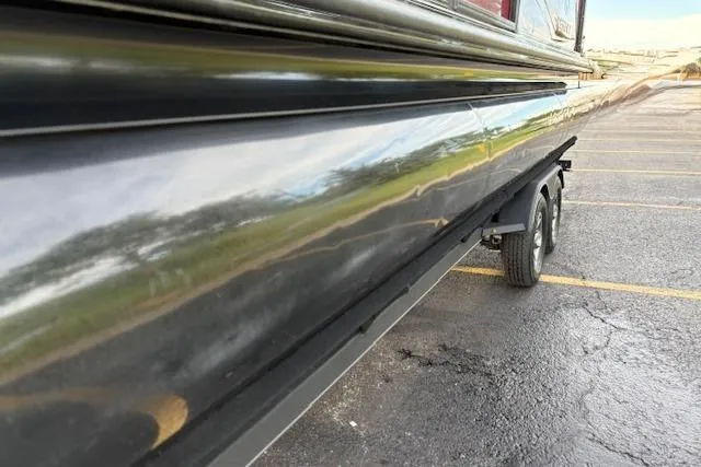 Slide: The Image of 2024 Regency 250 DL3 boat trailer side view in parking lot. - 16